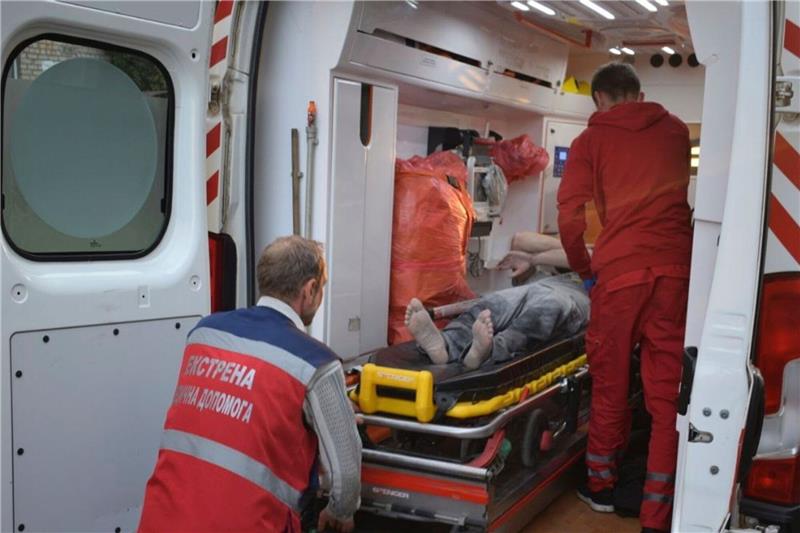 Sanitäter bereiten den Transport eines verletzten Mannes in eine naheliegende Klinik vor.