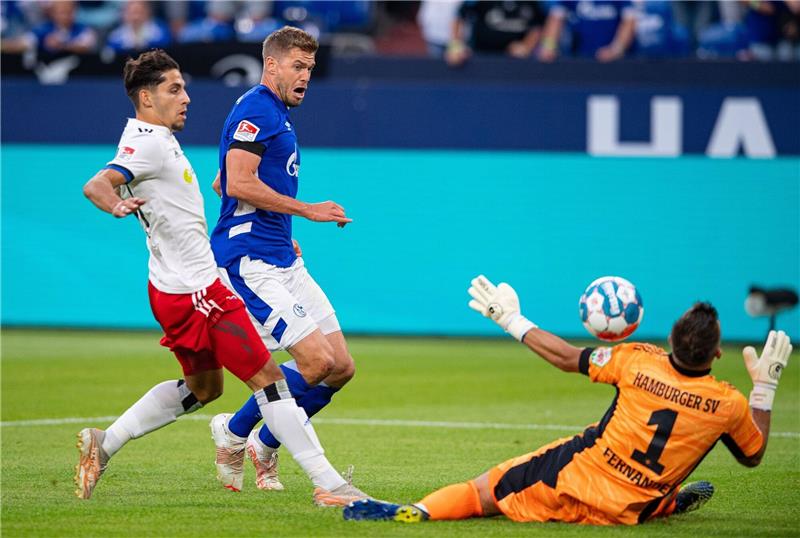 Schalkes Simon Terodde (M) erzielt gegen Hamburgs Ludovit Reis (l) und Hamburgs Torwart Daniel Heuer Fernandes das Tor zum 1:0.