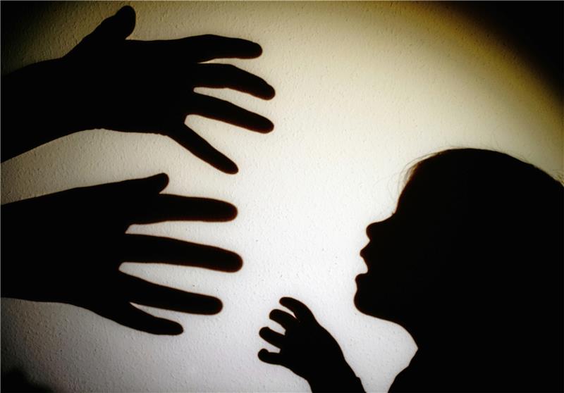 Schattenwirkung: Der Kopf eines Kindes und die Hände eines Erwachsenen dienen als Symbol dafür, dass nicht alle Mädchen und Jungen behütet aufwachsen.  Foto: Patrick Pleul/dpa