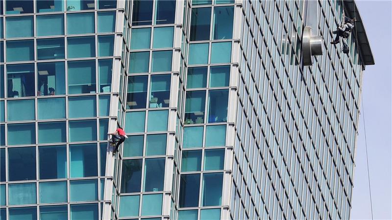 Schaulustige beobachteten Alex Honnold nicht nur vom Boden aus - auch hinter den Bürofenstern wurde der Extremsportler angefeuert.