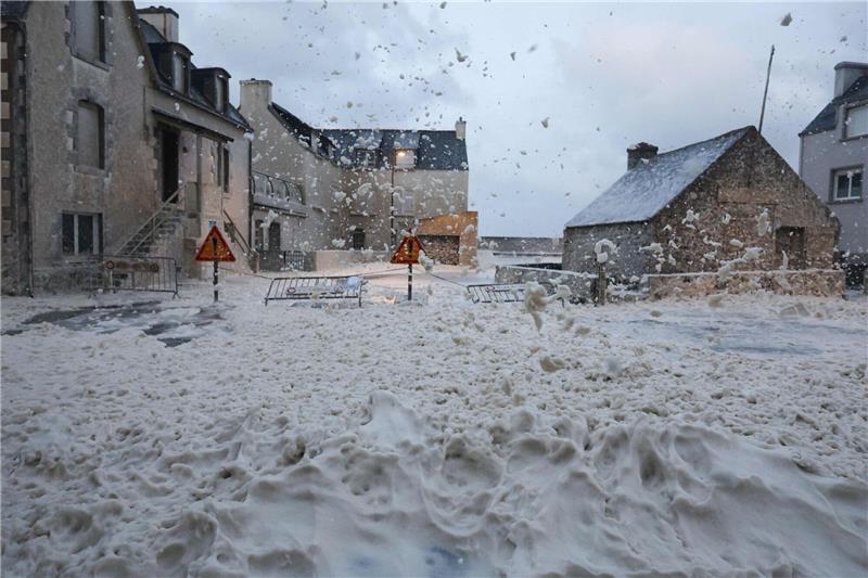 Orkantief trifft Westeuropa: Sieben Tote Schaum und Gischt fließen über eine Straße in Penmarc'h, Westfrankreich.