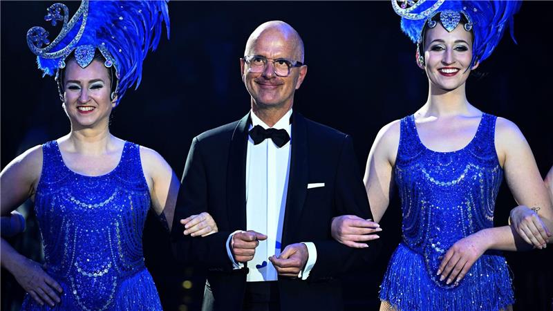 Schauspieler Christoph Maria Herbst geht mit Tänzerinnen im Rahmen des Balls „Soiree Münchner Leben“ zu seiner Verleihung des Karl-Valentin-Ordens 2026.