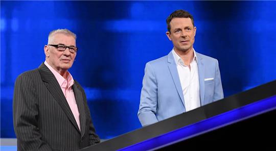 Schauspieler Heinz Hoenig steht neben „Gefragt - Gejagt“-Moderator Alexander Bommes. Foto: NDR/Uwe Ernst