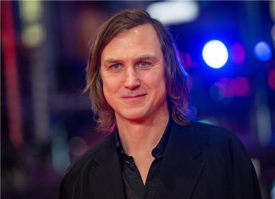 Schauspieler Lars Eidinger steht im Berlinale Palast auf dem Roten Teppich.