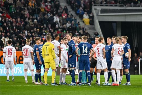 Schiedsrichter Felix Brych bespricht sich mit den Spielern am Mittelkreis.