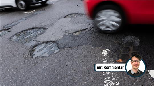 Autos fahren auf einer Straße durch Schlaglöcher.