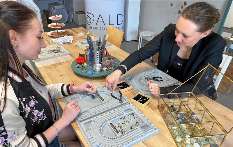 Sonne verwöhnt „Kunstharz“-Marktplatz in Braunlage Schmuckdesignerin Laura Matthes (re.) zeigt in ihrer Harzmade-Werkstatt den Workshop-Teilnehmern am Samstag, wie Steine richtig zur Geltung gebracht werden. Fotos: Nachtweyh/Jung(2)