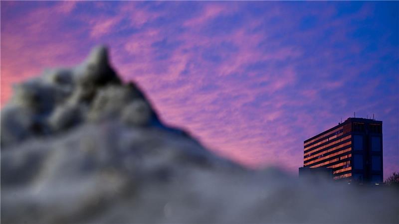 Schnee liegt am Morgen vor einem Berliner Hochhaus. 