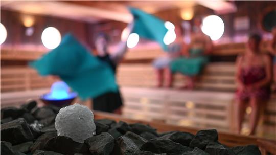 Schneebälle aus Crushed Ice liegen in der Koggen-Sauna in Ostfriesland neben einem Sauna-Ofen - vielleicht etwas für einen kalten Wintertag?