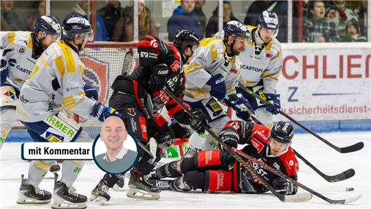 Mehrere Eishockey-Spieler kämpfen auf dem Eis um den Puck.