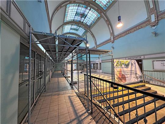 Schön ist das nicht, aber der Tunnel, der aus Baugerüsten errichtet worden ist, schützt die Fahrgäste wenigstens vor herabfallendem Glas aus dem maroden Dach. Der mittlere Bereich der Halle bleibt nach wie vor abgeriegelt. Auch die Treppe hinunter zum Bahnsteig ist nicht nutzbar. Foto: Schlegel