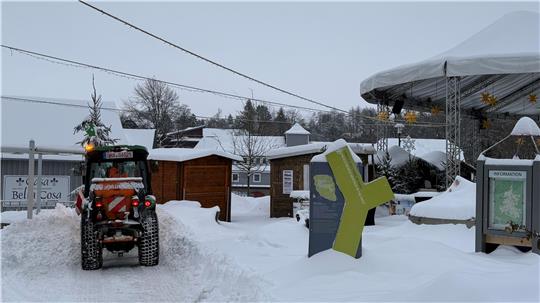 Ein kleiner Traktor räumt Schnee.