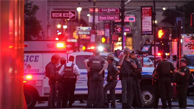 Bilder des Tages Schüsse in New York: Polizisten versammeln sich auf der 52. Straße vor einem Bürogebäude, in dem mehrere Menschen erschossen wurden.