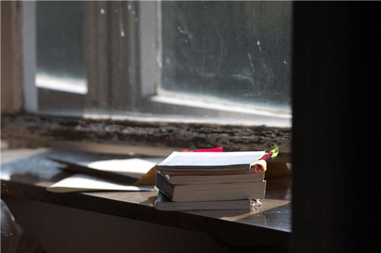 Schulbücher liegen auf einer Fensterbank.