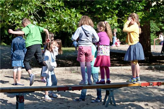 Kinder spielen auf einem Spielplatz.