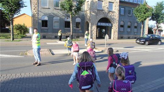 Schulwegsicherer helfen den Kindern die Straße zu überqueren.
