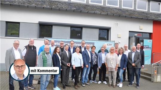 Gruppe von Menschen steht vor einem Gebäude mit CDU-Bannern im Hintergrund