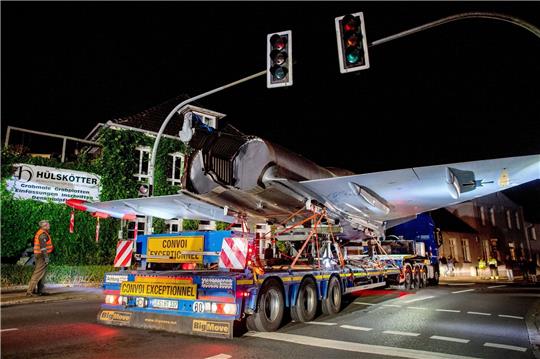 Schwertransporter fährt mit einem Kampfflugzeug vom Typ Eurofighter Typhoon durch das Stadtzentrum.