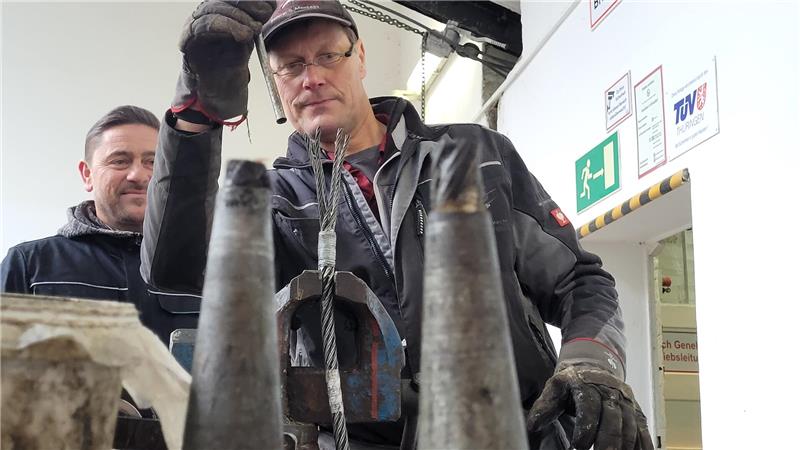 Seiler Peter Weiß zieht die Enden des Zugseils auseinander und fächert sie anschließend auf. Im Vordergrund zu sehen die alten Gusskegel.