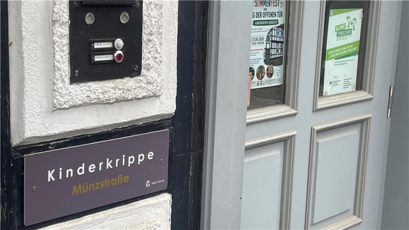 Tür mit grauem Rahmen und schwarzem Klingelschild mit der Aufschrift 'Kinderkrippe'