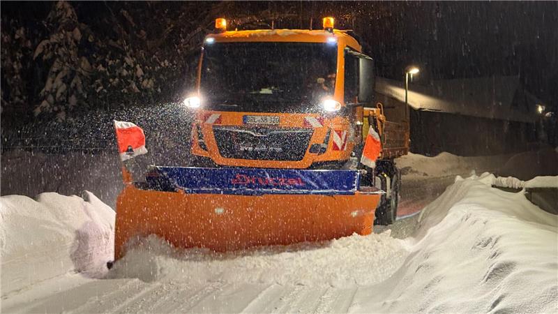Das Foto zeigt einen Schneepflug in der Nacht.