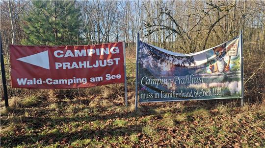 Das Bild zeigt zwei Banner, die auf den Campingplatz Prahljust hinweisen.