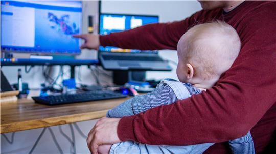 Sicher nicht ganz einfach: Ein junger Vater arbeitet im Homeoffice mit seinem Sohn. (Symbolbild)
