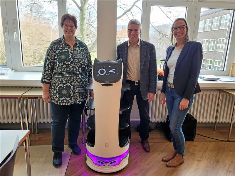 Sie kann zwinkern, sprechen und auf den Gast reagieren – Bella ist mehr als nur ein fahrendes Tablett. Abteilungsleiterin Bettina Mull (v.l.), Schulleiter Jens Büsing und Lehrkraft Manuela Bäumler sind stolz auf die Anschaffung des Roboters. Foto: Exner