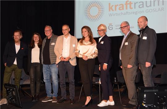 Sie strahlen Optimismus aus für Goslar: Referent Stefan Poster, GMG-Chefin Marina Vetter, Lars Bornemann, Burkhard Naffin, Moderatorin Mara Bergmann, Antje Röttcher, Lars Dörhage und Uwe Schwenke de Wall. Der neue „Kraftraum“ soll zur Ideenschmiede werden, damit die Wirtschaftsregion Goslar für die Zukunft noch besser mit ihren Muskeln spielt. Und er soll die Leidenschaft für Goslar vertiefen. Foto: Kleine