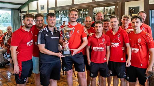 Siegerehrung auf nassen Fliesen: Dörntens Fußballobmann Christian Schwarze (3. v. l.) überreicht den Bärenkopfpokal an den Sieger VfL Liebenburg.