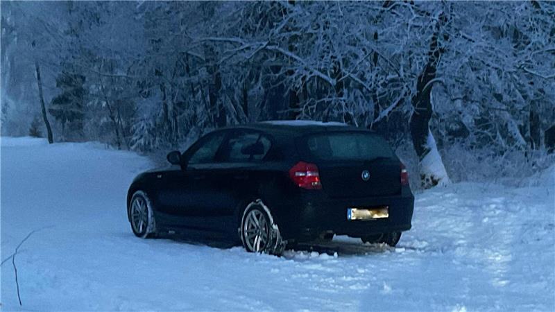Das Foto zeigt einen schwarzen Kleinwagen im Schnee.