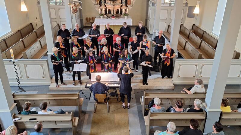 Silke Ahlgrim die Co-Chorleiterin dirigiert den Chor und Klaus Heure speilt Klavier