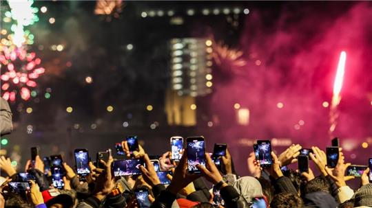 Silvester in Düsseldorf: Raketen zum neuen Jahr steigen in den Himmel, Tausende Menschen am Rheinufer feiern fröhlich.