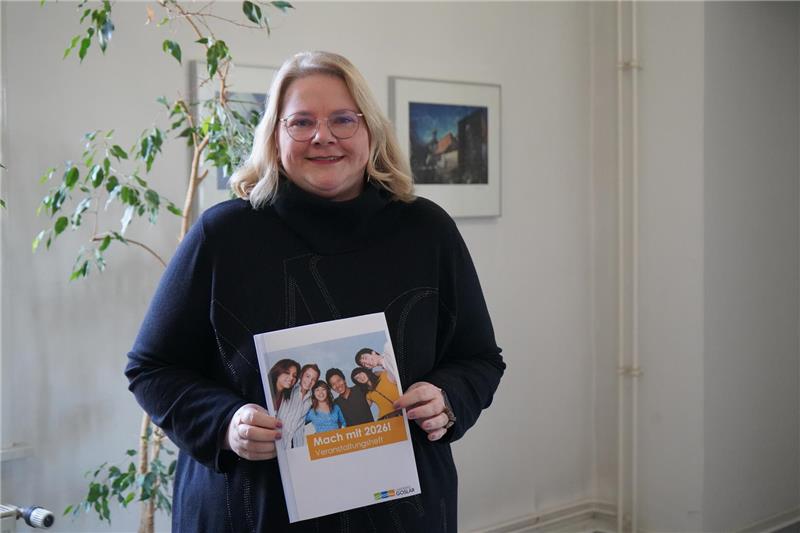 Eine Frau hält eine Bröschüre in der Hand.