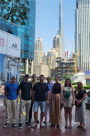 Eine Gruppe steht vor Hochhäusern in Dubai.