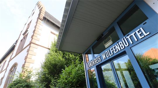 Eingangsbereich eines Gebäudekomplexes, über der Glastür steht "Landkreis Wolfenbüttel".