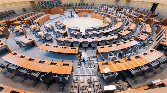 Sitze und Tische werden im Plenum des Landtags umgebaut. Der Bundestag wird von 733 auf 630 Abgeordnete verkleinert.