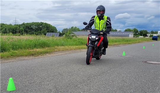 Das Bild zeigt einen Motorradfahrer, der um Gummihütchen herum Slalom fährt.