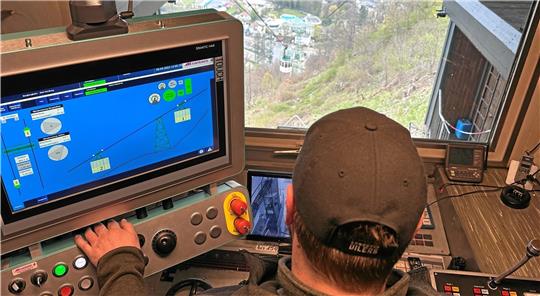 So bedient man heutzutage eine Bergbahn: Im Steuerstand in der Bergstation zeigt ein Monitor die Position und den Status der Gondeln an. Es ist die genaue Wiedergabe dessen, was der Mann am Führerstand auch aus seinem Panoramafenster sieht. Die Bedienung der Anlage ist nun vollautomatisch, wird aber natürlich trotzdem noch von Menschen überwacht. Foto: Schlegel