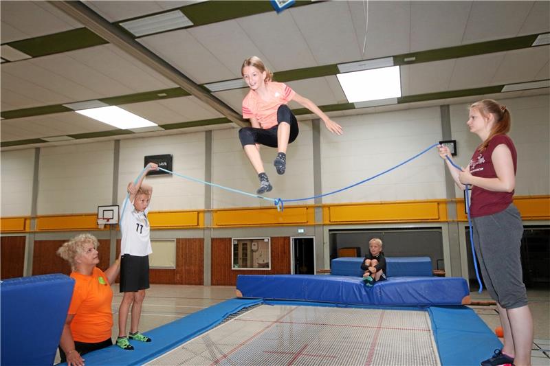 So hoch wie möglich springt Tonia über das Seil, Julian (hinten) und Marlon (2. v. li.) sind danach dran. Tina Kaminski (li.) und Saskia Oloff (re.) geben ihren Schützlingen Tipps, wie sie den Sprung am besten meistern.  Fotos: Düber