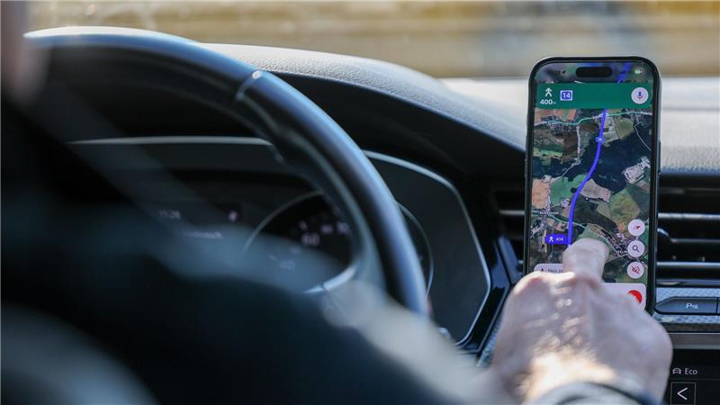 So ist es derzeit erlaubt: Das Handy steckt in der Halterung und wird nur kurz vom Fahrer beachtet. (Symbolbild)