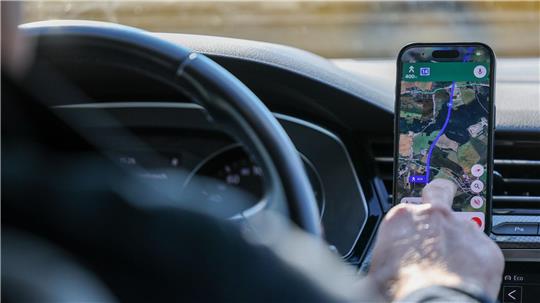 So ist es derzeit erlaubt: Das Handy steckt in der Halterung und wird nur kurz vom Fahrer beachtet. (Symbolbild)