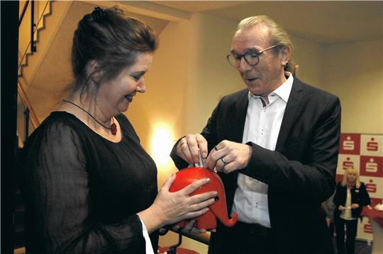 So locker sitzt das Goslarer Geld beim Kämmerer sonst nicht: Erster Stadtrat Dirk Becker zahlt als Besucher beim Neujahrsempfang in der Kaiserpfalz in den Abzucht-Elefanten von GZ-Redakteurin Sabine Kempfer ein. Foto: Epping
