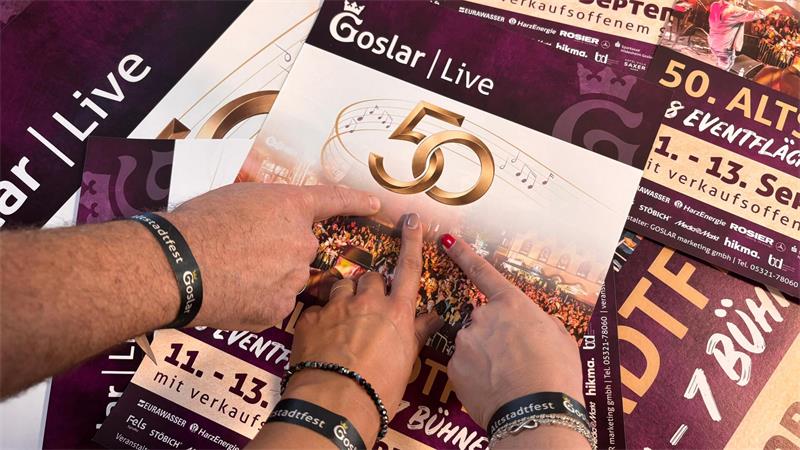 Handgelenke mit drei Armbändern, darunter ein schwarzes Stoffarmband mit weißer Aufschrift 'Altstadtfest'.
