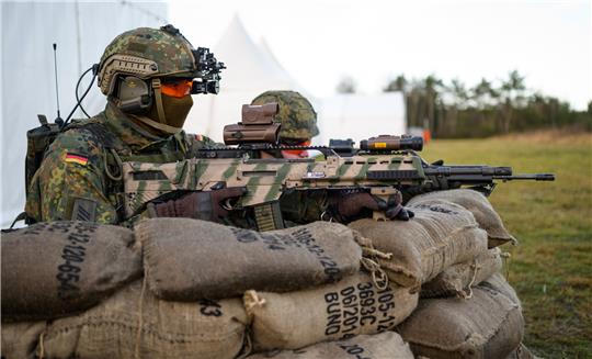 Soldaten der Bundeswehr beziehen mit dem Sturmgewehr vom Typ G36 A2 während einer Vorführung hinter Sandsäcken Stellung. Foto: Philipp Schulze/dpa