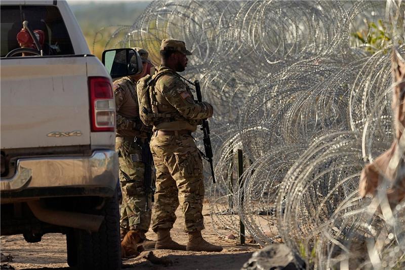 Biden verteidigt Ausbau von Grenzmauer Soldaten stehen neben einem Stacheldrahtzaun am Ufer des Rio Grande Wache.