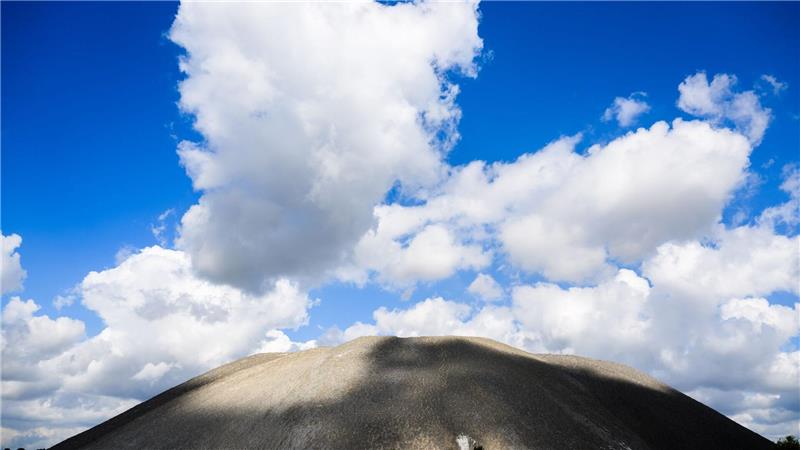 Sonne und Wolken sorgen für Licht und Schatten auf einem Kaliberg in der Region Hannover.