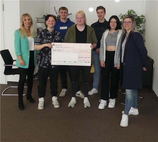 Sparkassen-Filialleiterin Melanie Apel hat einen Scheck ausgestellt über die Summe, die Leonie, Lukas, Maja Jane, Niko und Amy mit ihrer Lehrerin Christiane Bodmann (v. li.) zur Bank gebracht haben. Foto: Römhild