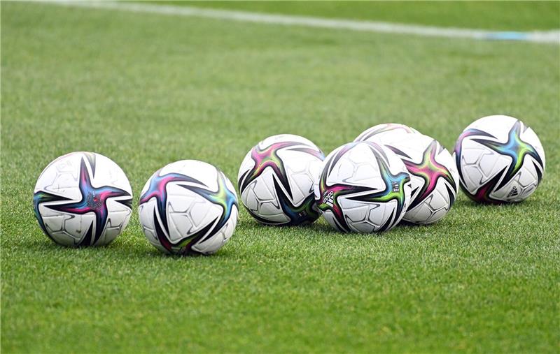 Spielbälle liegen auf dem Rasen.