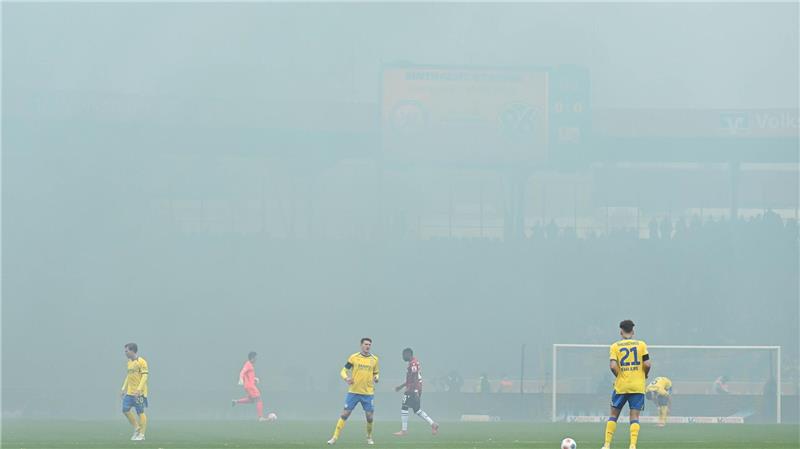 Rot nach Würgegeste: Hannover gewinnt hitziges Derby Spieler im Nebel: Das Derby zwischen Eintracht Braunschweig und Hannover 96 wird nach dem Abbrennen von Pyrotechnik im Hannover-Fanblock kurz unterbrochen.